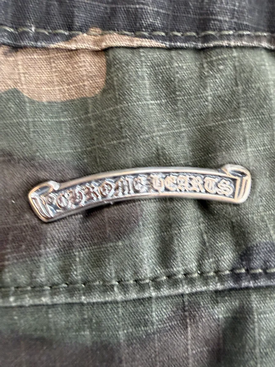 Крупный план серебряной плашки с логотипом Chrome Hearts