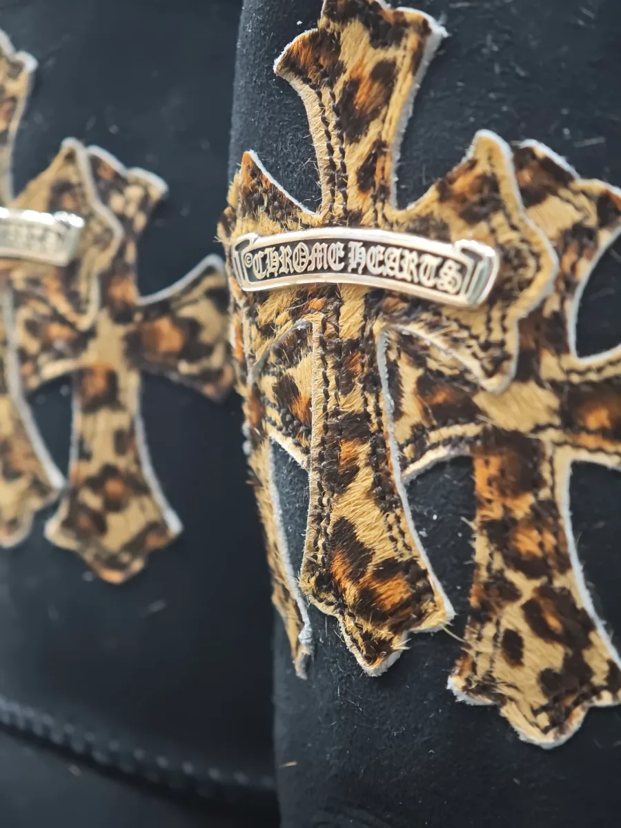 Крупный план серебряной фурнитуры Chrome Hearts на леопардовом кресте