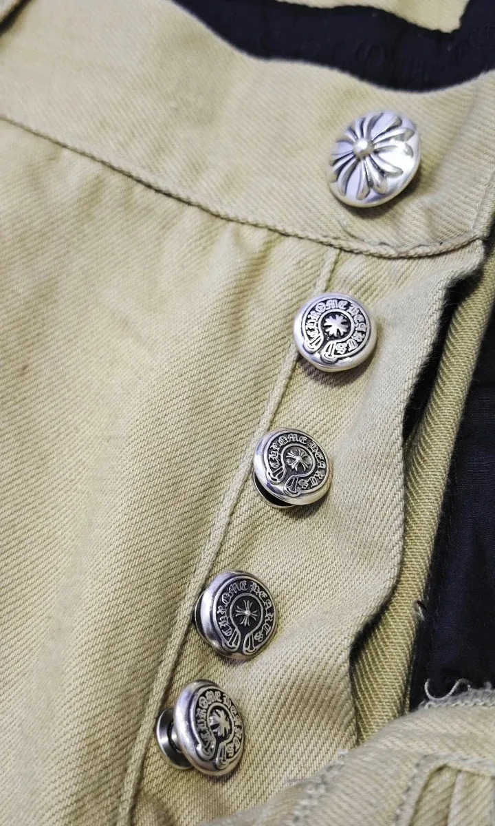 Металлические пуговицы-болты с гравировкой Chrome Hearts на ширинке бежевых штанов
