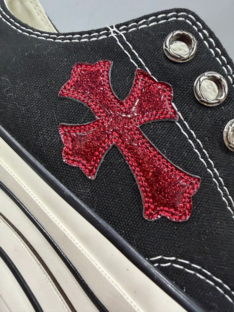 Крупный план красного блестящего кожаного креста на боковой панели кед Chrome Hearts x Converse