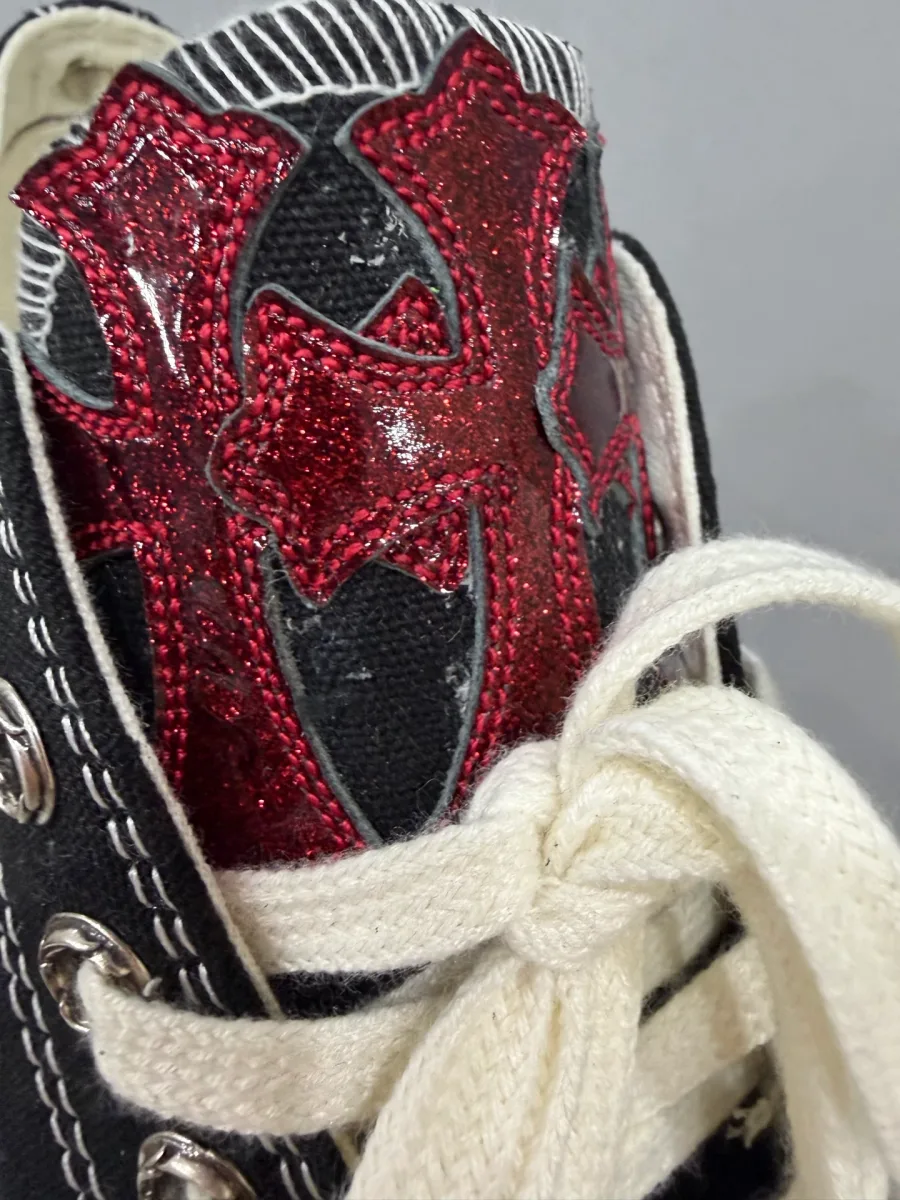 Крупный план язычка кед Chrome Hearts x Converse с красным кожаным крестом
