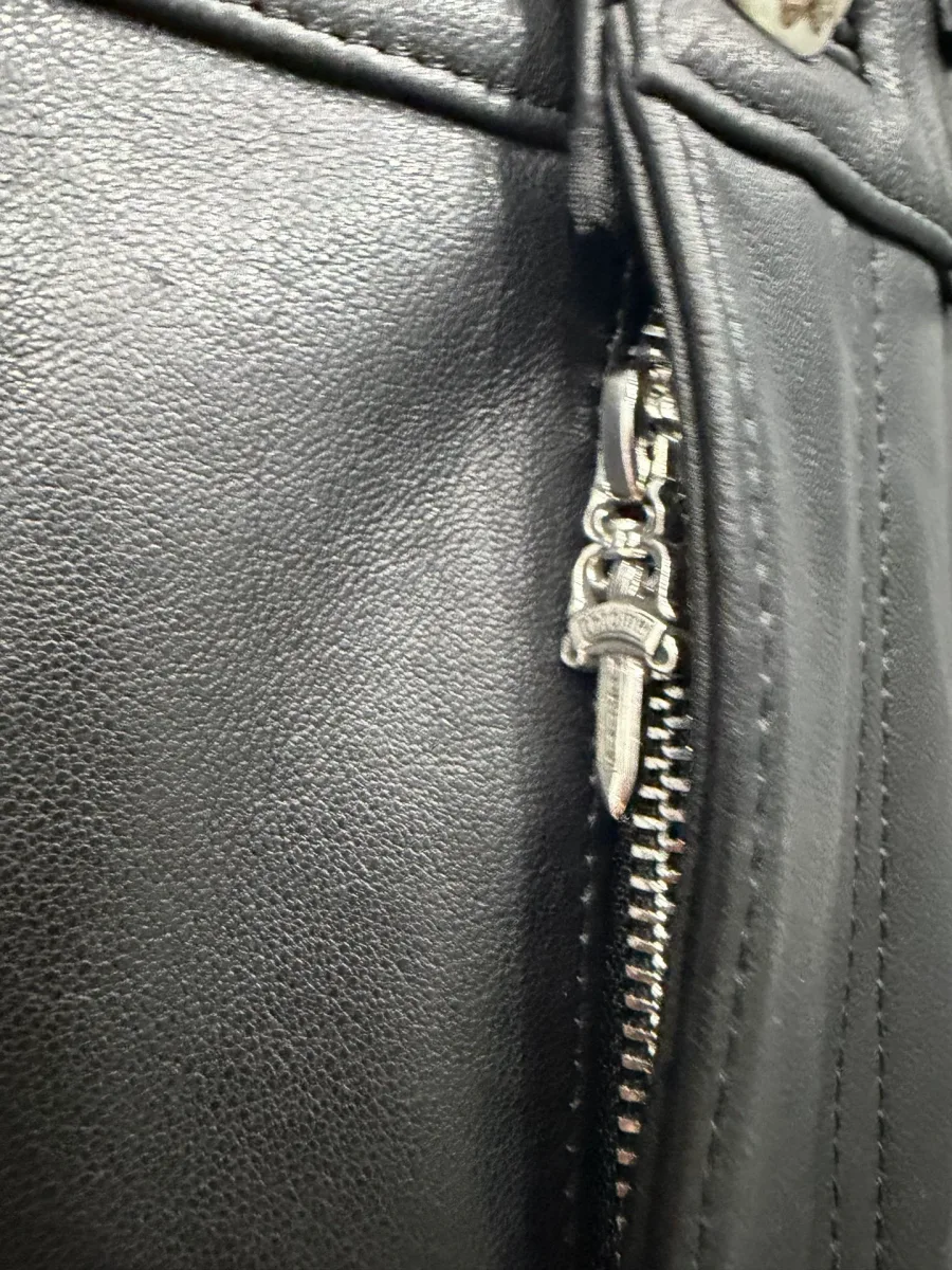 Металлическая молния с бегунком-кинжалом Chrome Hearts на кожаной юбке