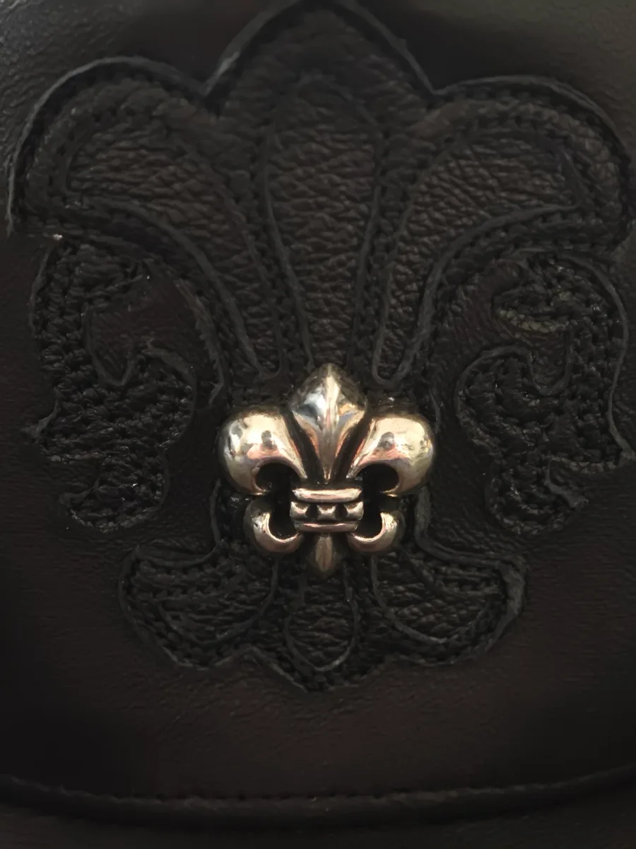 Крупный план нашивки в виде лилии на кепке Chrome Hearts