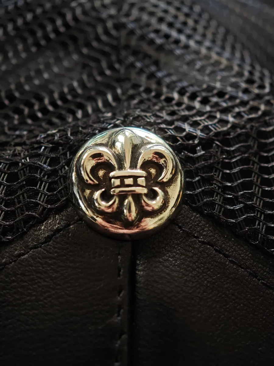 Серебряная пуговица с гравировкой лилии на кепке Chrome Hearts