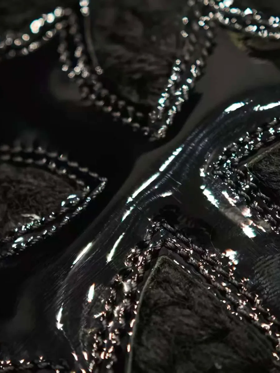 Крупный план строчки на лаковом кресте Chrome Hearts