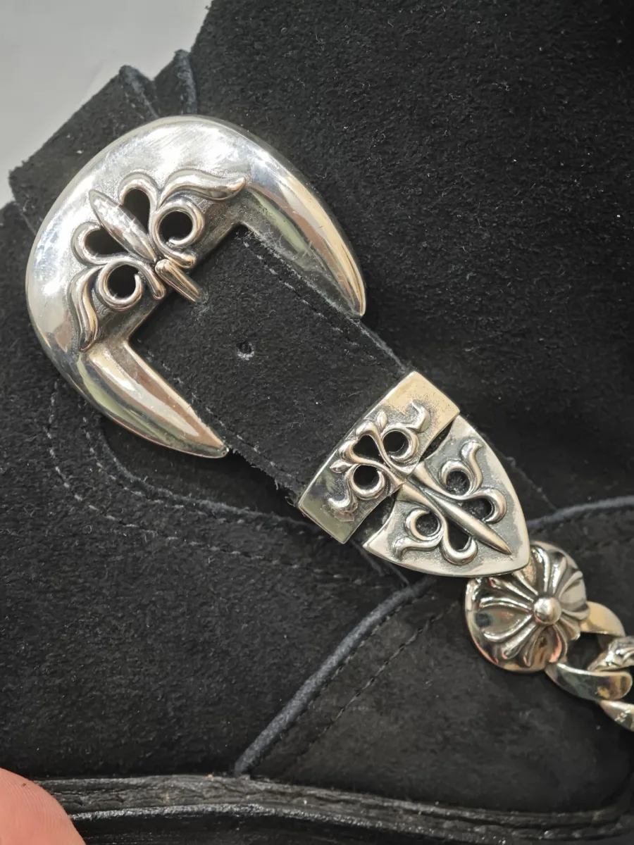 Крупный план серебряной пряжки с геральдическим узором Chrome Hearts