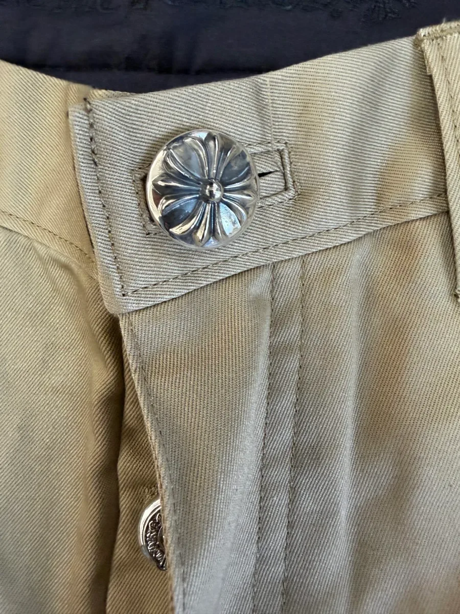 Фирменная пуговица-болт брюк Chrome Hearts крупным планом