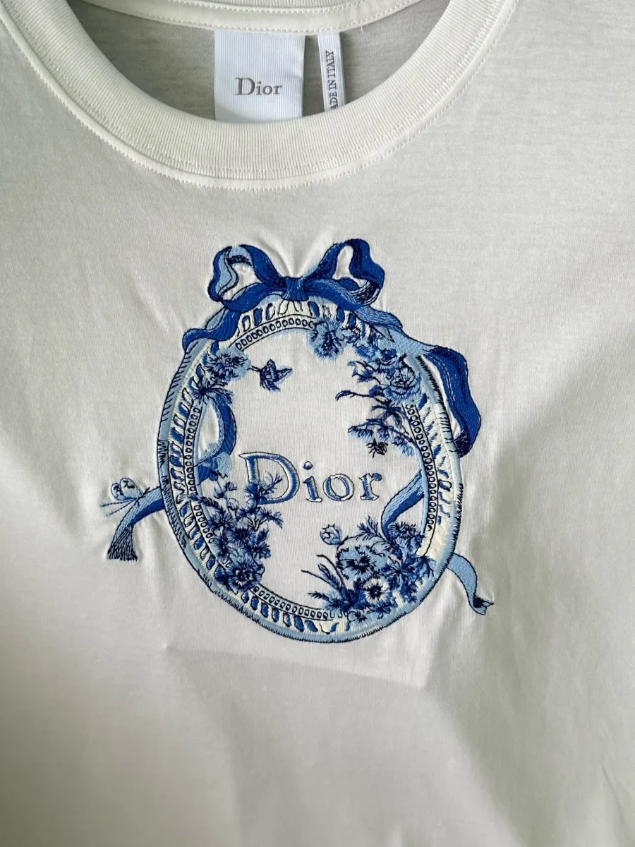 Крупный план синего принта в виде медальона с бантом и логотипом Dior