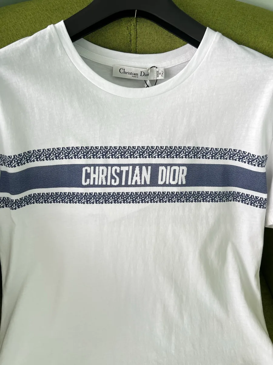 Вырез горловины и горизонтальная синяя полоса с логотипом Christian Dior крупным планом