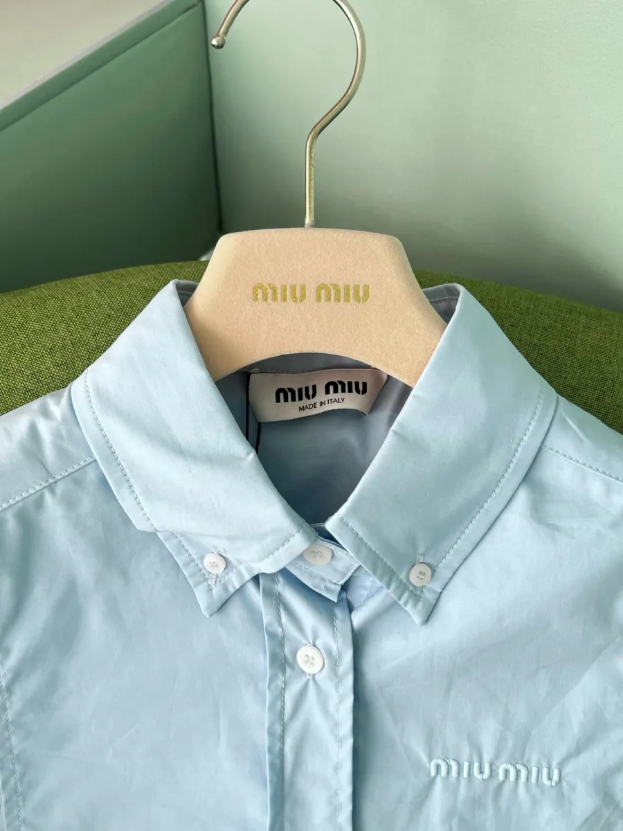 Воротник button-down и пуговицы на голубом хлопковом топе-манишке крупным планом