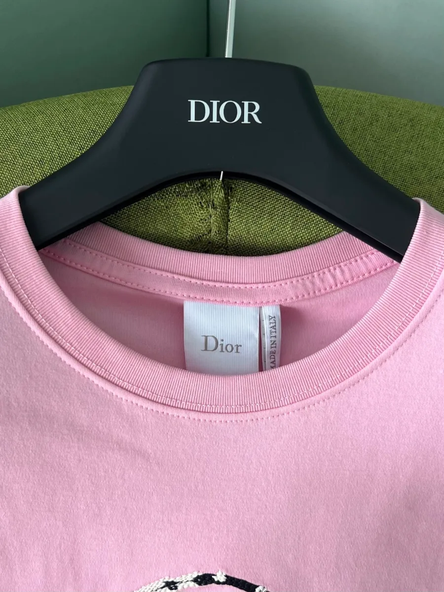 Круглый вырез горловины розовой футболки с внутренней биркой Dior