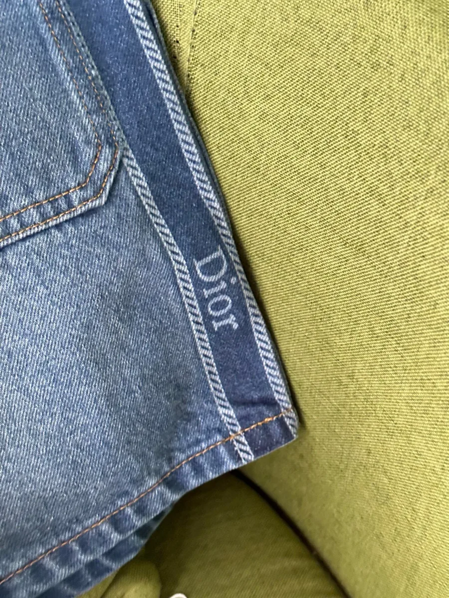 Крупный план синего тканевого лампаса с надписью Dior сбоку шорт