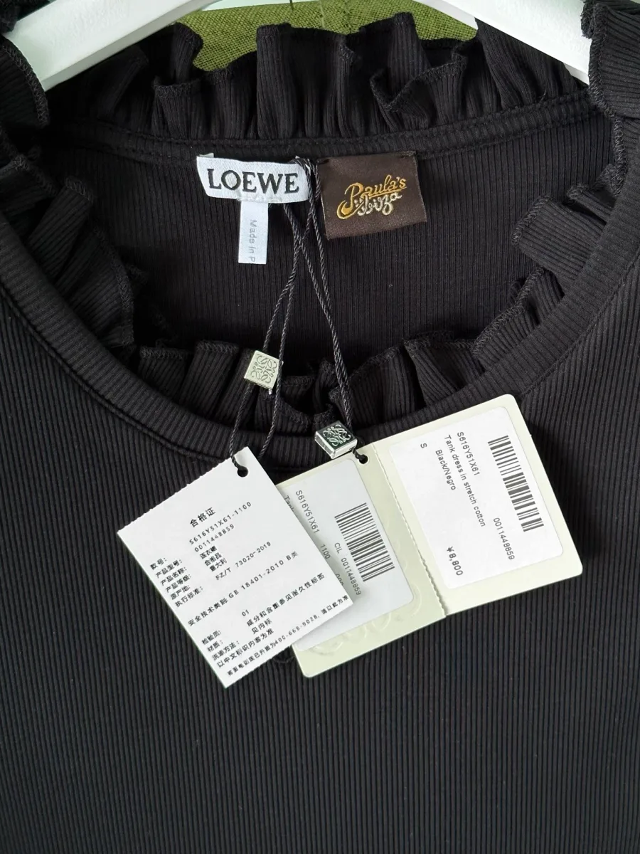 Навесные ярлыки и бирки Loewe на фоне чёрного фактурного трикотажа