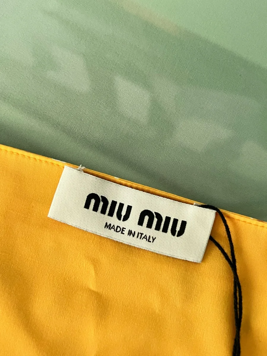 Тканевый ярлык с логотипом Miu Miu и надписью Made in Italy