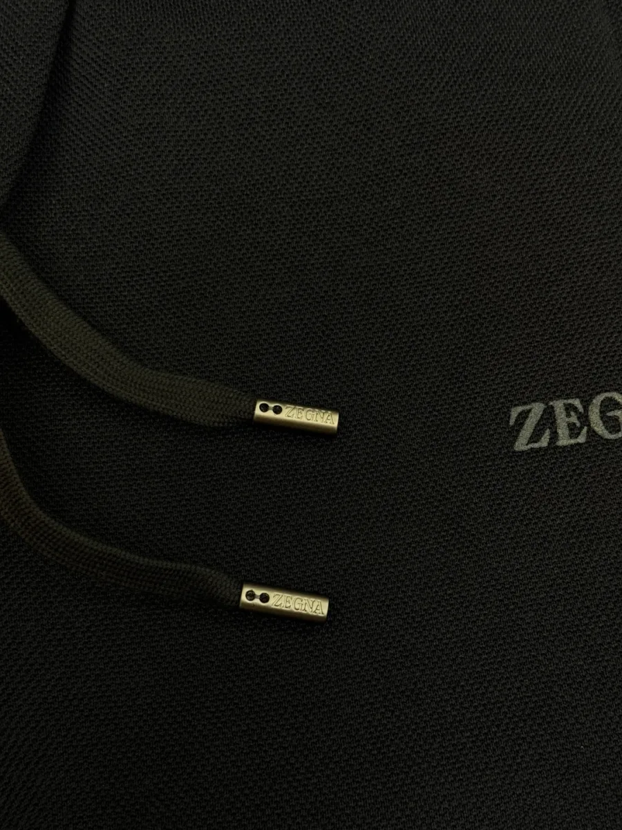Фактурный трикотаж брюк, наконечники шнурка и вышивка ZEGNA крупным планом