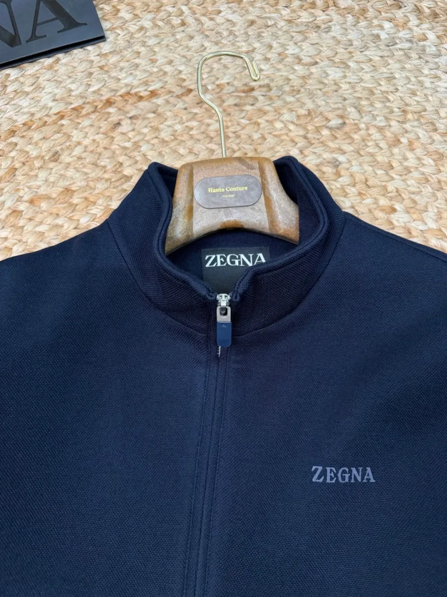 Воротник-стойка, металлическая молния и вышивка ZEGNA на куртке крупным планом