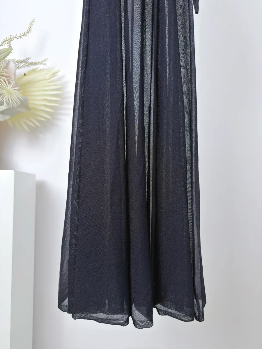 Расклешённый плиссированный подол чёрного платья макси