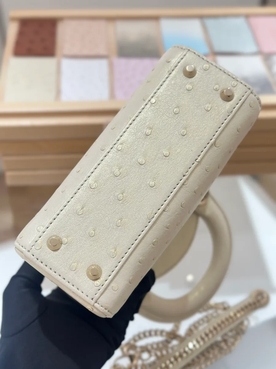 Дно бежевой сумки Lady Dior 17 из кожи страуса с металлическими ножками