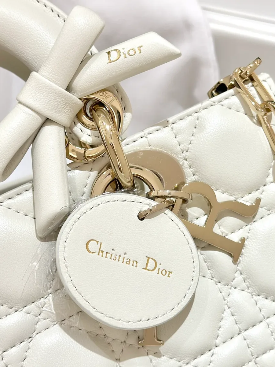 Деталь кожаного ярлыка с тиснением Christian Dior и металлических подвесок