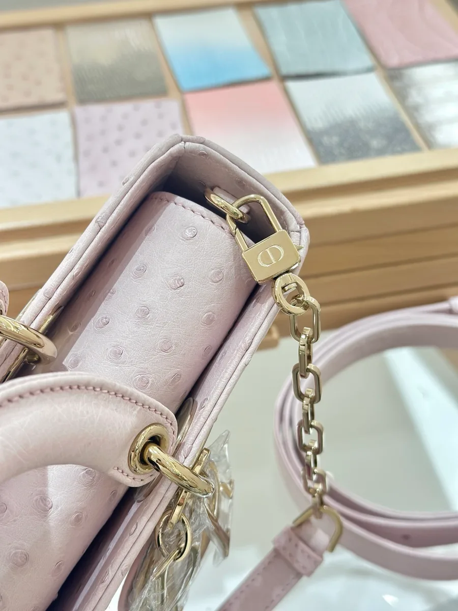 Боковая сторона розовой сумки Dior Lady D-Joy из кожи страуса с креплением ремня