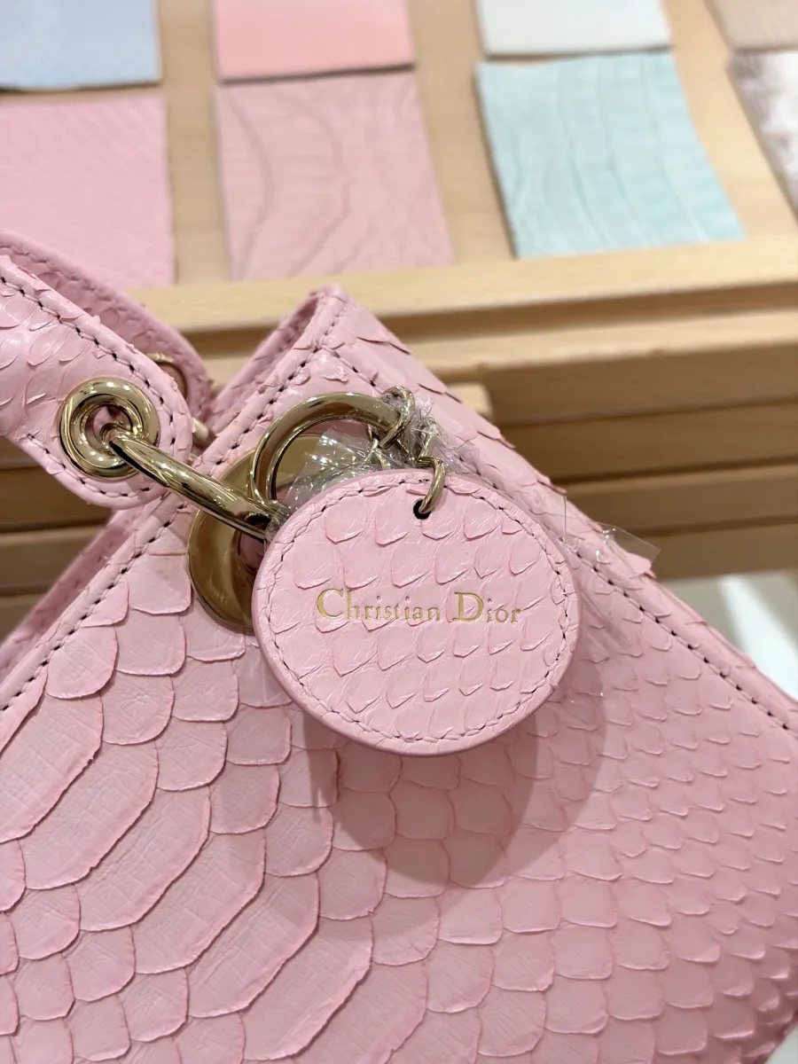 Крупный план круглого кожаного ярлыка Christian Dior под креплением ручки