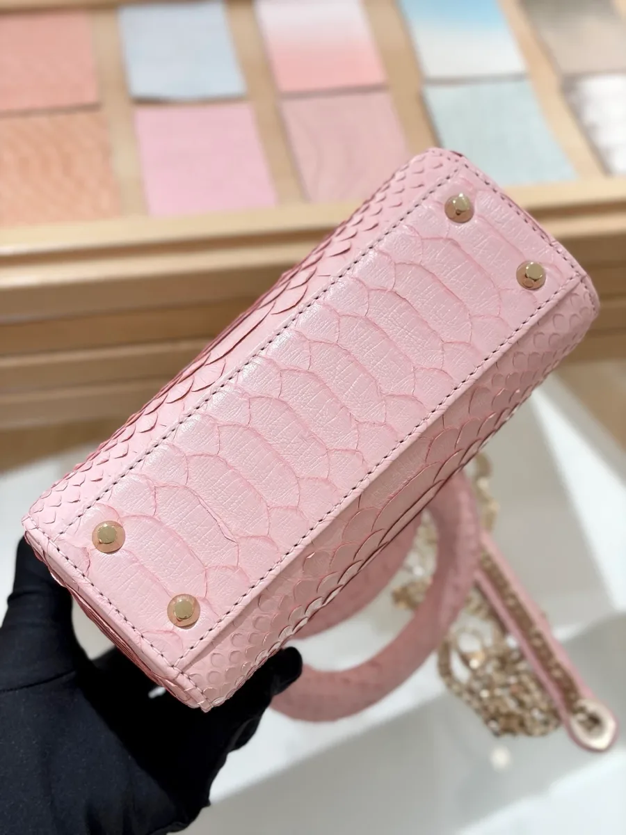 Вид на дно розовой сумки Lady Dior 17 из кожи змеи с металлическими ножками