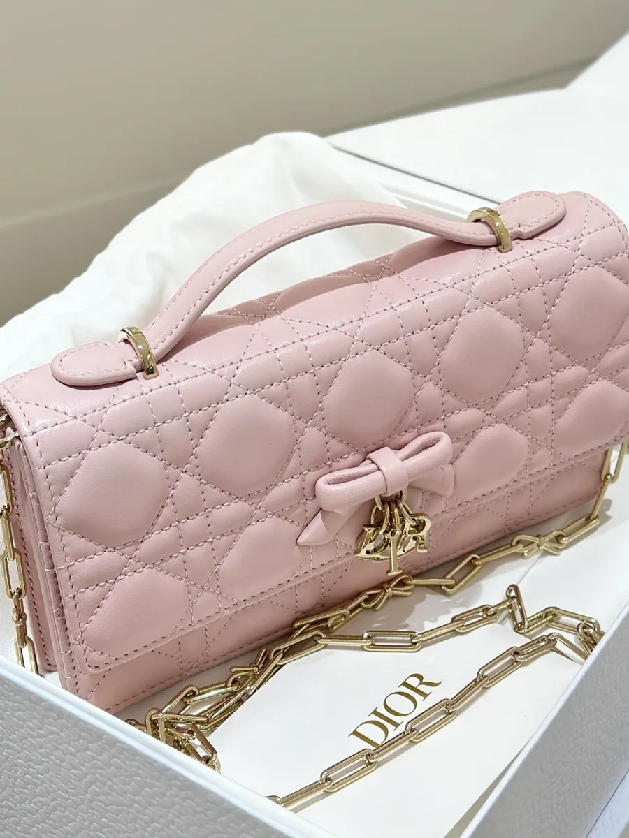 Розовая сумка-клатч Dior WOC с бантом, вид в три четверти в коробке