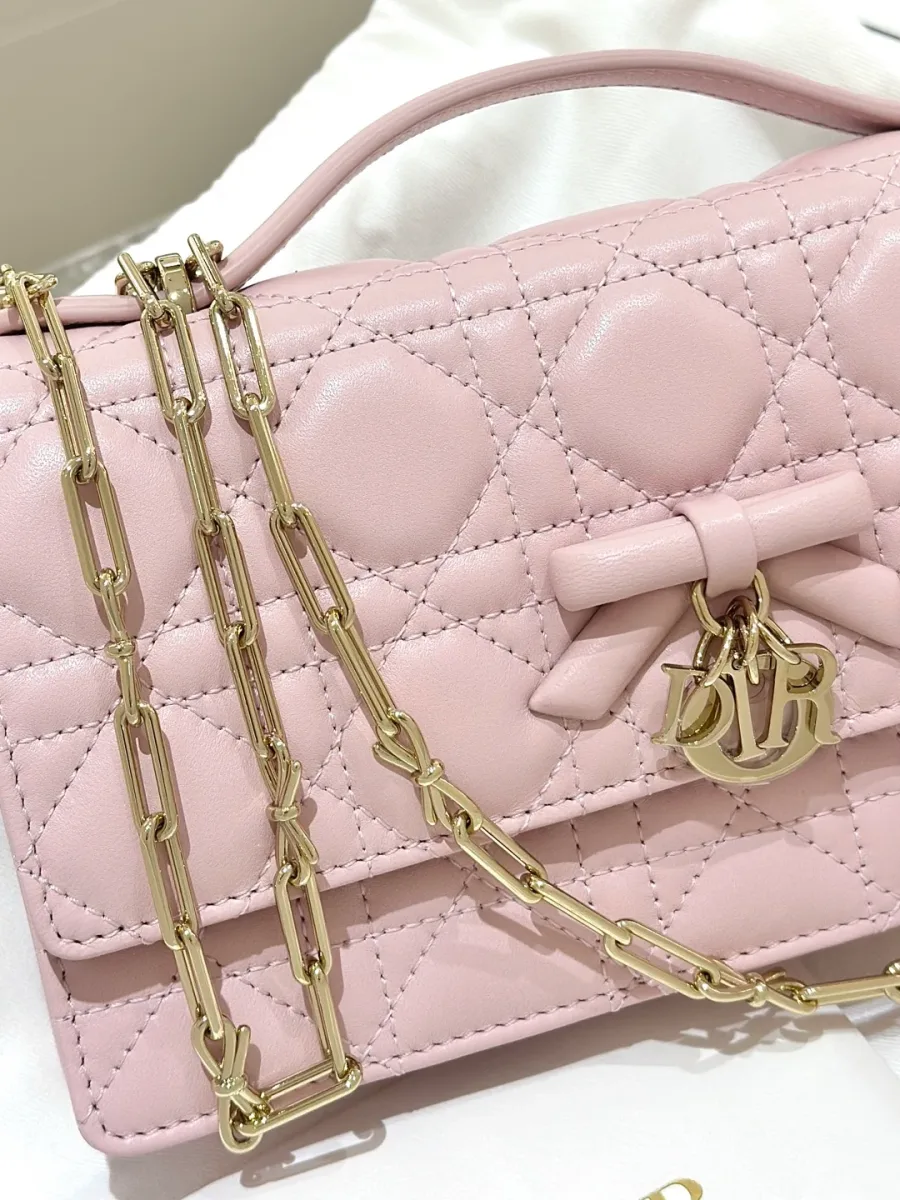 Розовая сумка-клатч Dior WOC с золотистой цепочкой крупным планом