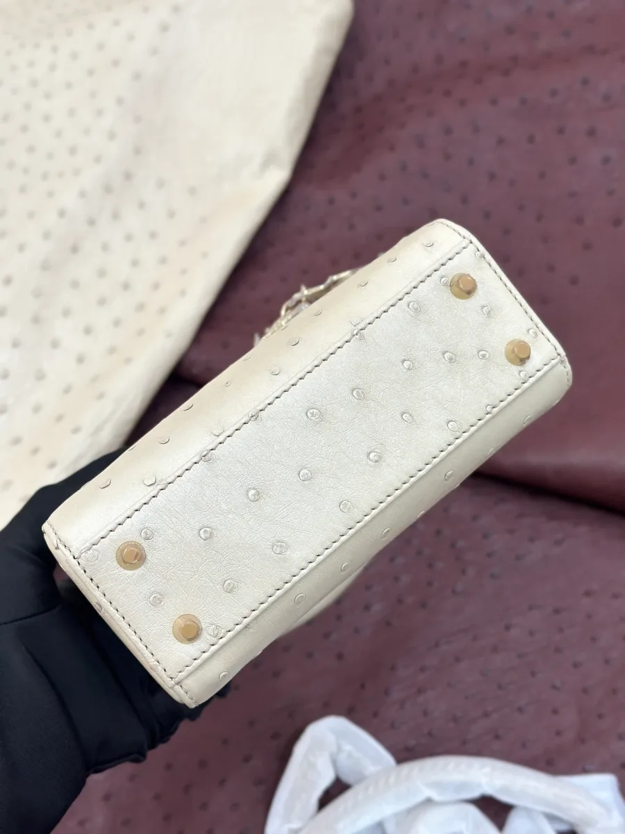 Дно бежевой сумки Lady Dior с металлическими ножками-заклепками