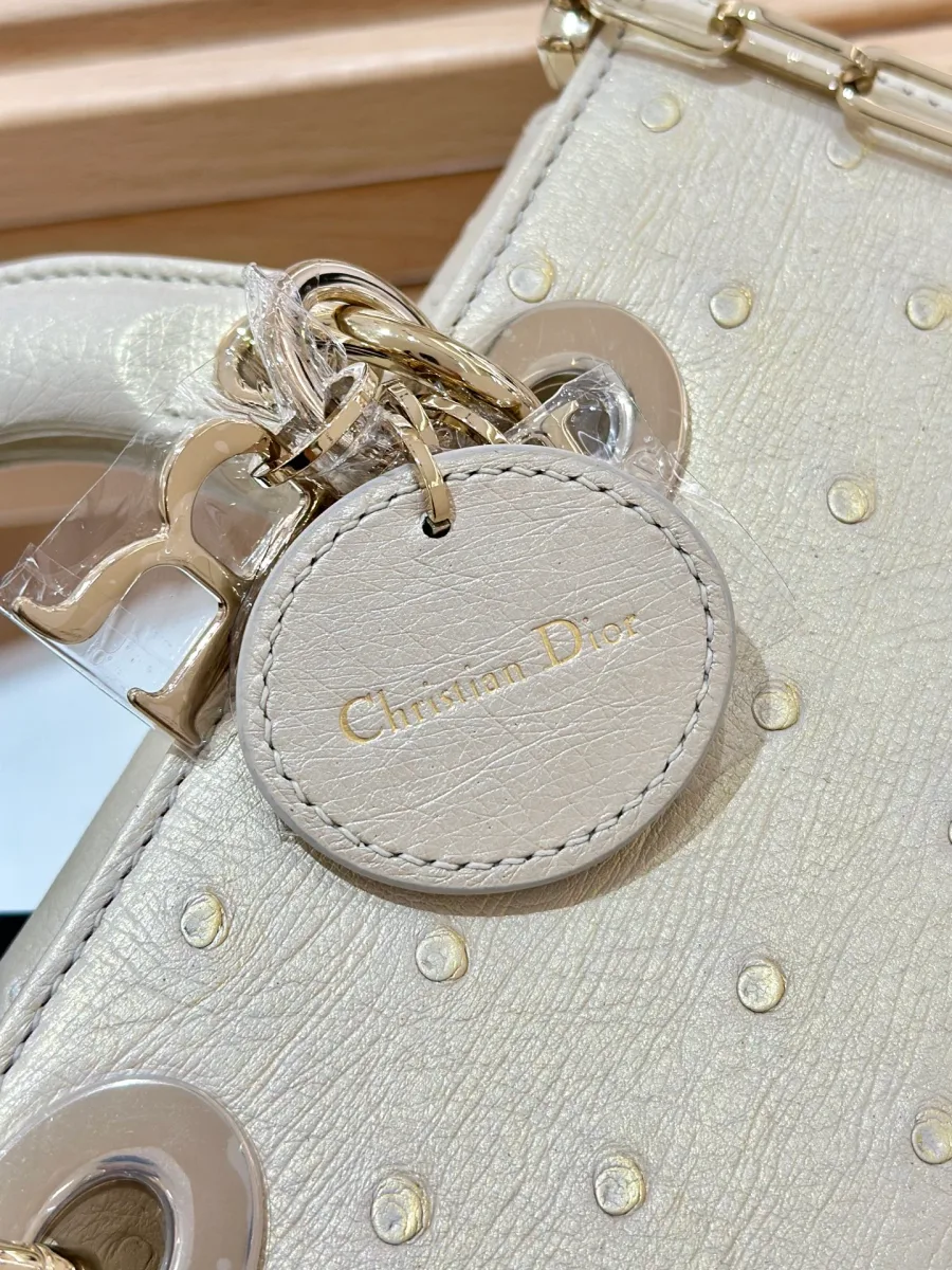 Крупный план кожаного ярлыка с тиснением Christian Dior и металлической подвески