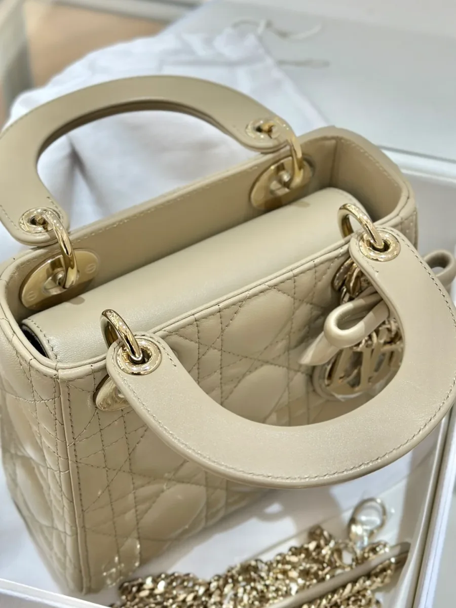 Вид сверху на закрытую бежевую сумку Lady Dior с двумя ручками