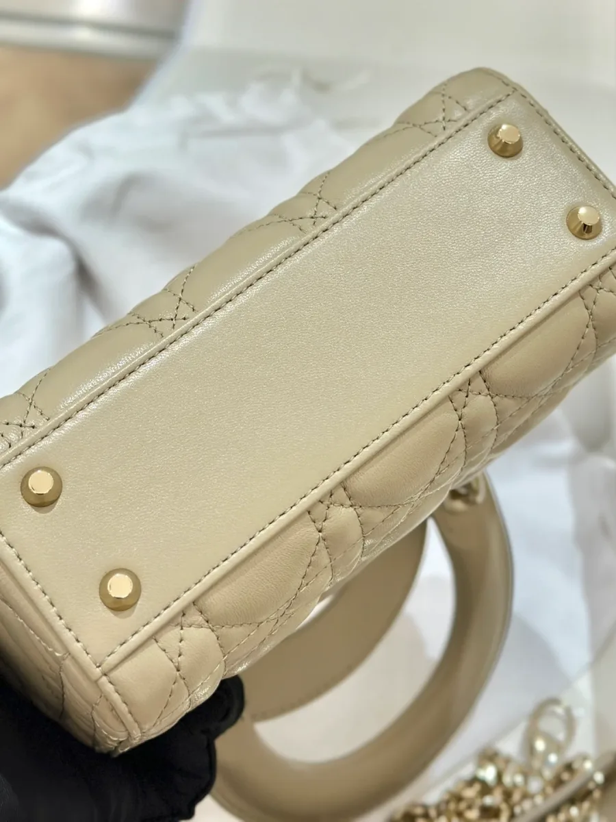 Нижняя часть бежевой сумки Lady Dior с металлическими защитными ножками