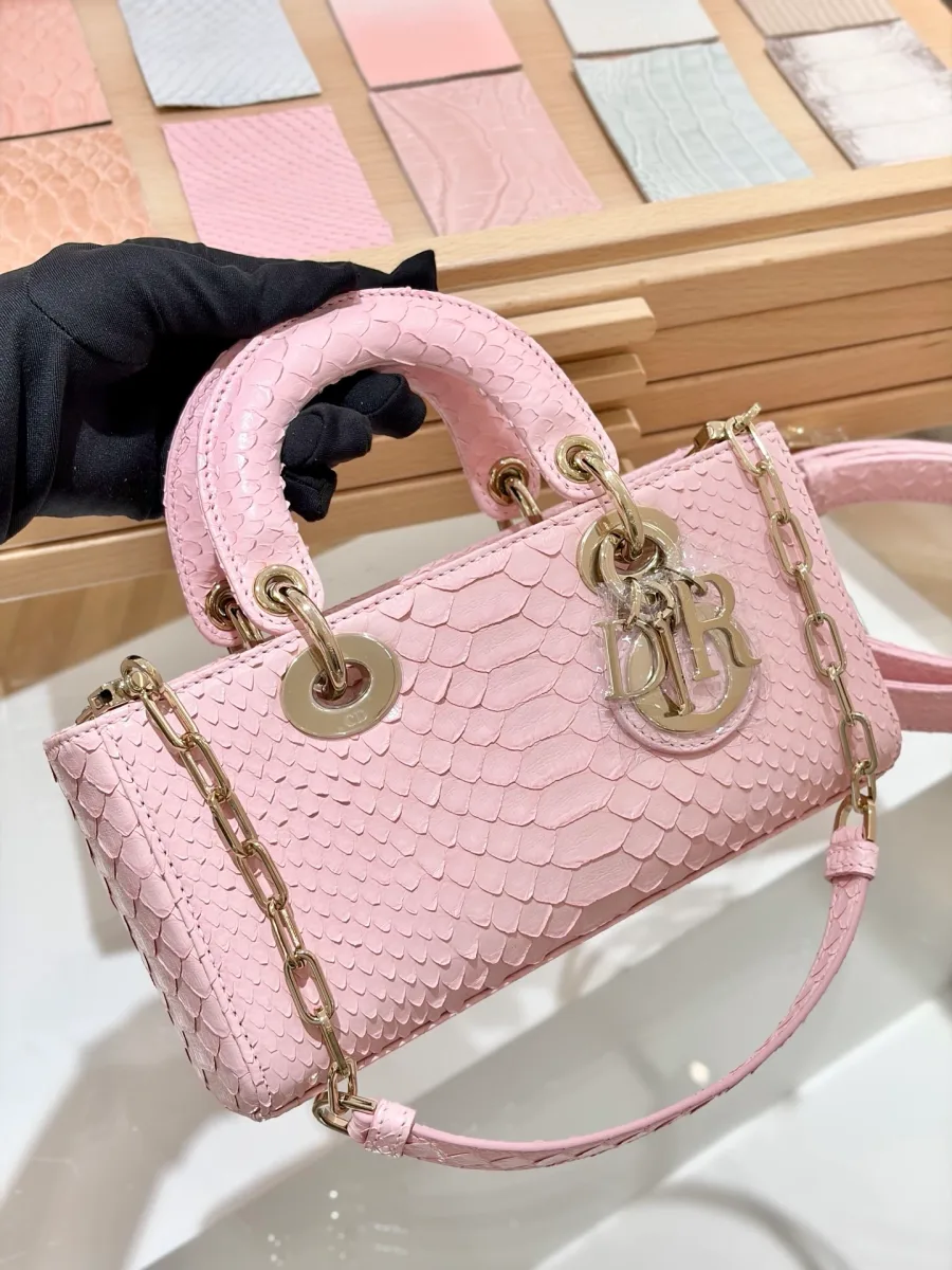 Розовая сумка Dior Lady D-Joy 22 из кожи змеи, вид спереди в руке