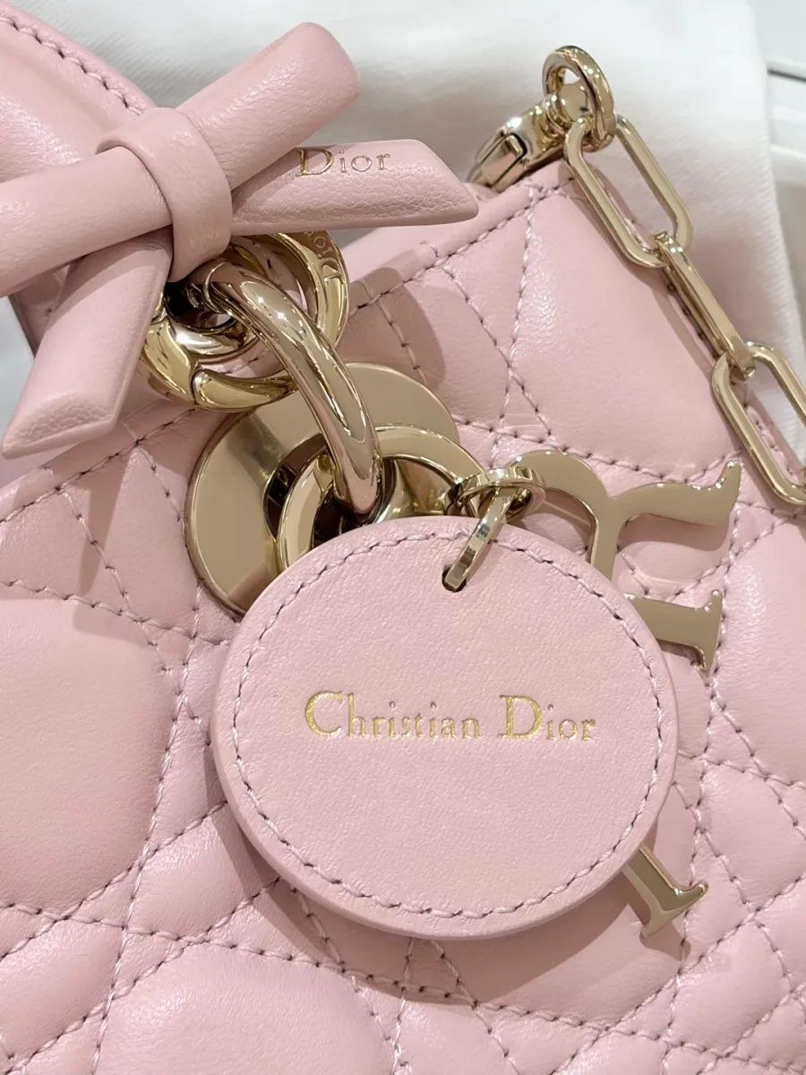 Обратная сторона кожаного круглого ярлыка Christian Dior на розовой сумке