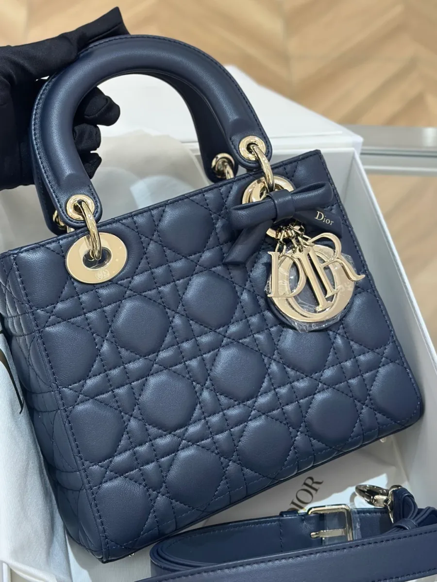 Синяя сумка Lady Dior с золотистой фурнитурой и подвеской-бантом, вид спереди