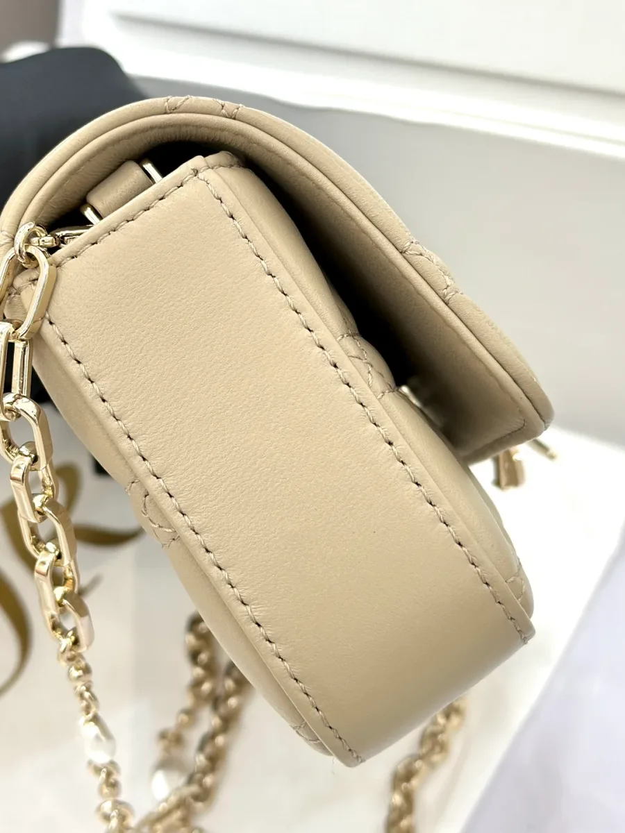 Вид сбоку на бежевый клатч Dior WOC, демонстрирующий толщину