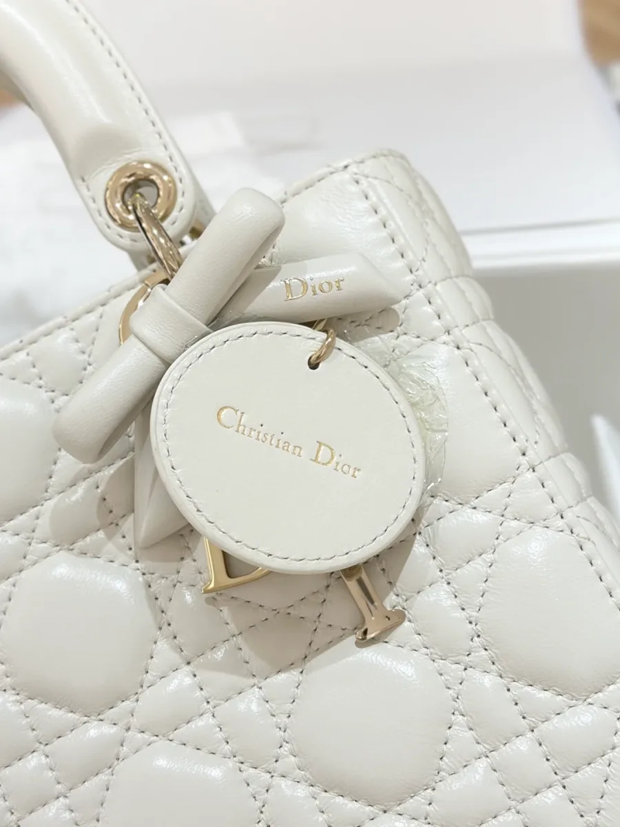 Крупный план круглого кожаного ярлыка Christian Dior и подвески с бантом