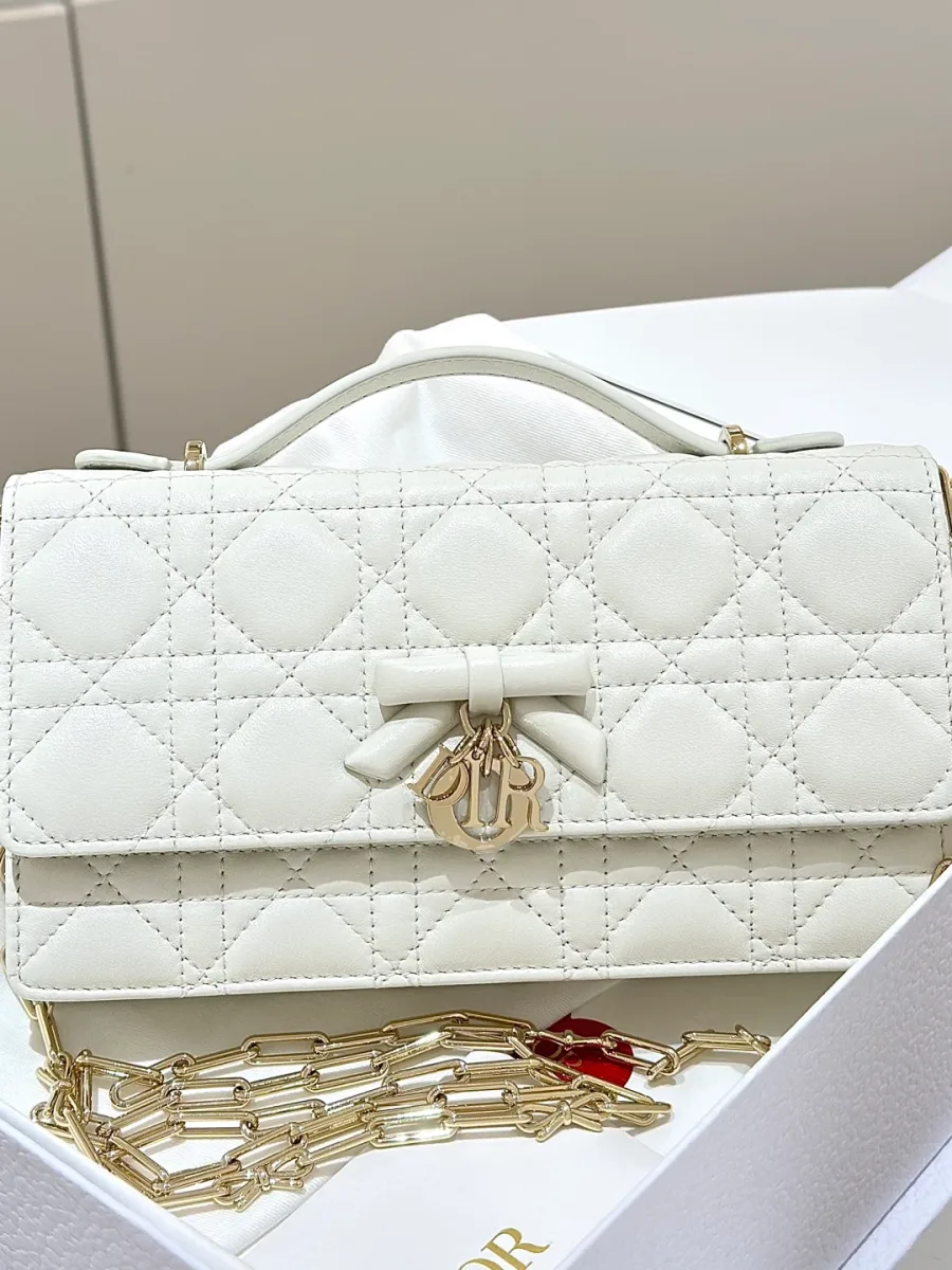 Белая сумка WOC с узором Cannage, бантом и золотистой подвеской DIOR, вид спереди