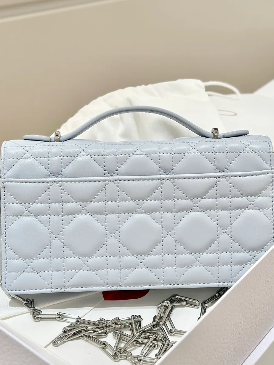 Голубая сумка Dior WOC с культовым стеганым узором Cannage, вид сзади с плоским карманом.