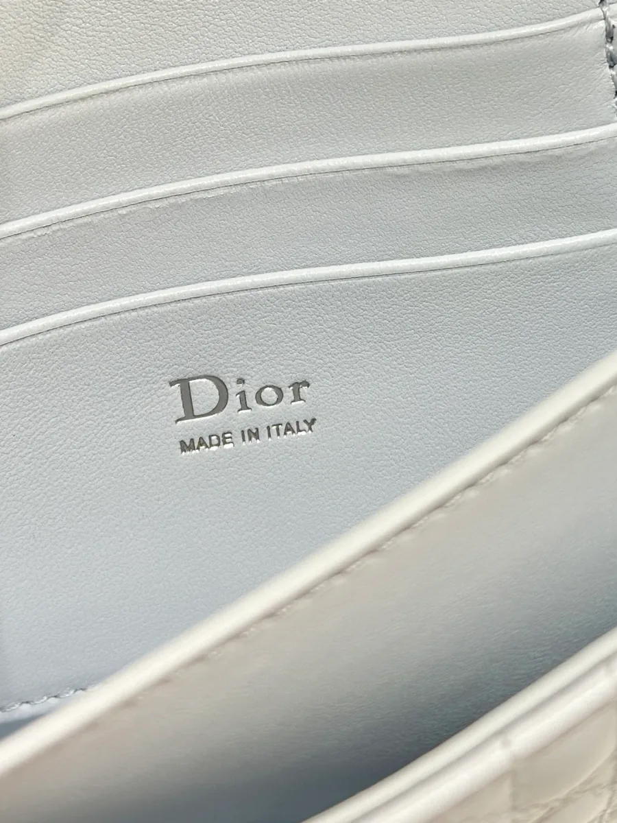 Крупный план серебристого тиснения логотипа Dior Made in Italy внутри сумки.