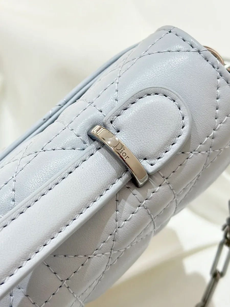 Крупный план металлического крепления верхней ручки с гравировкой Dior.