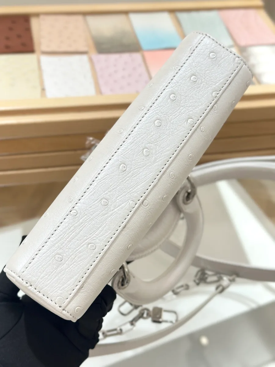 Вид на нижнюю часть белой сумки Dior Lady D-Joy 22 из кожи страуса