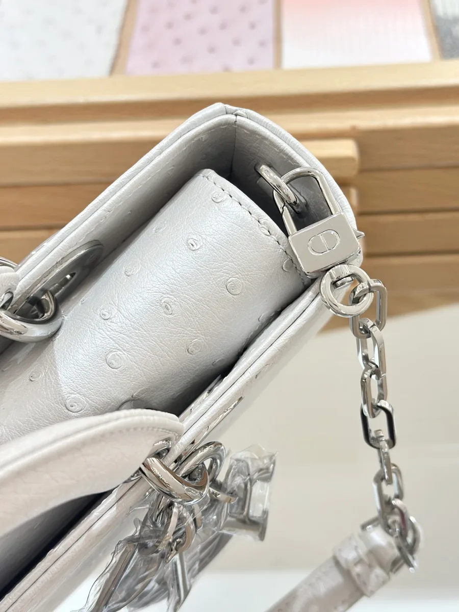 Крупный план бокового крепления ремня и текстуры кожи страуса сумки Dior Lady D-Joy 22