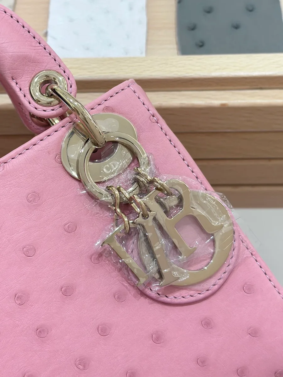 Крупный план золотистой металлической подвески с буквами DIOR