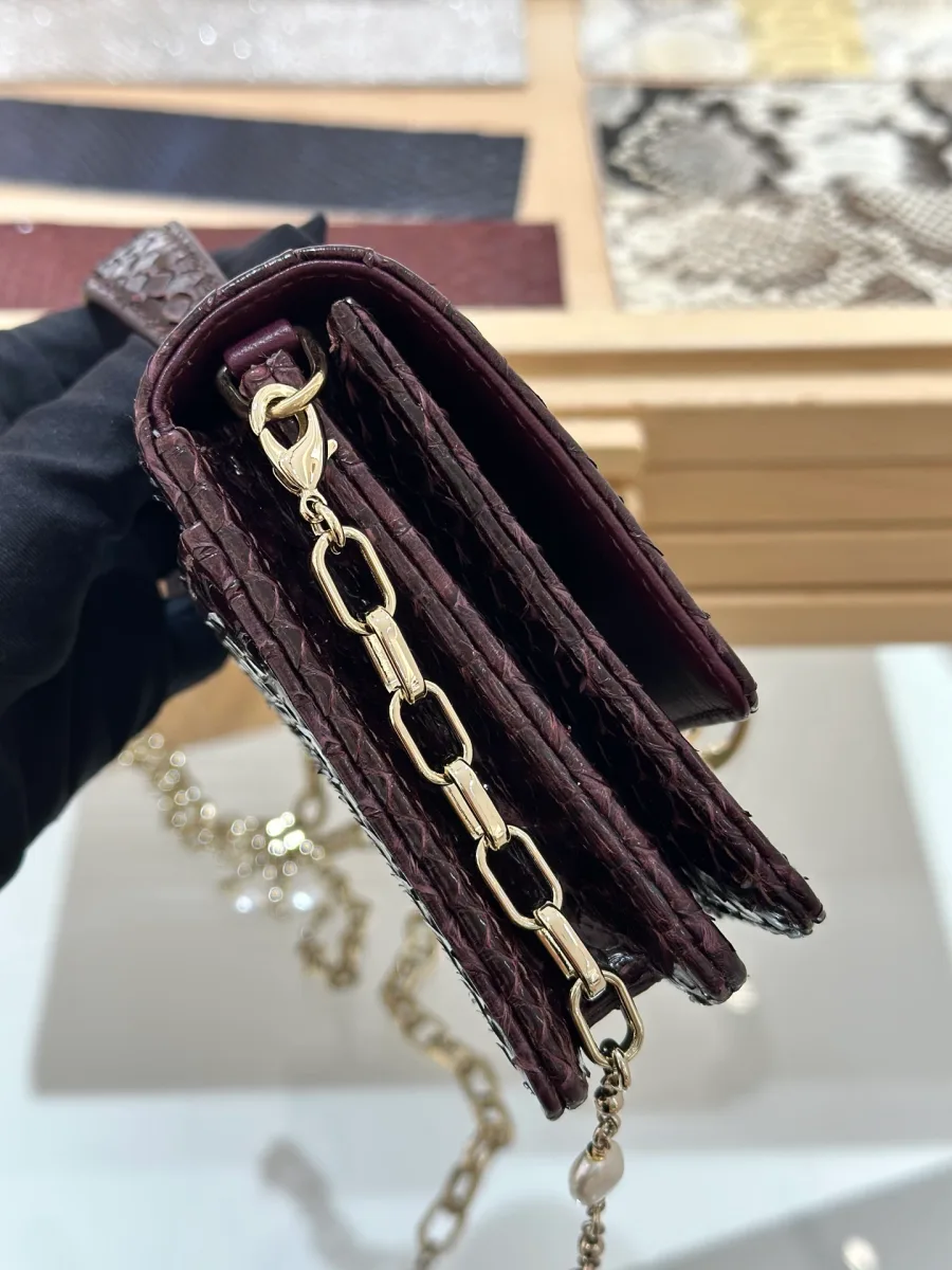 Боковая сторона бордового клатча Dior WOC, демонстрирующая гармошку отделений