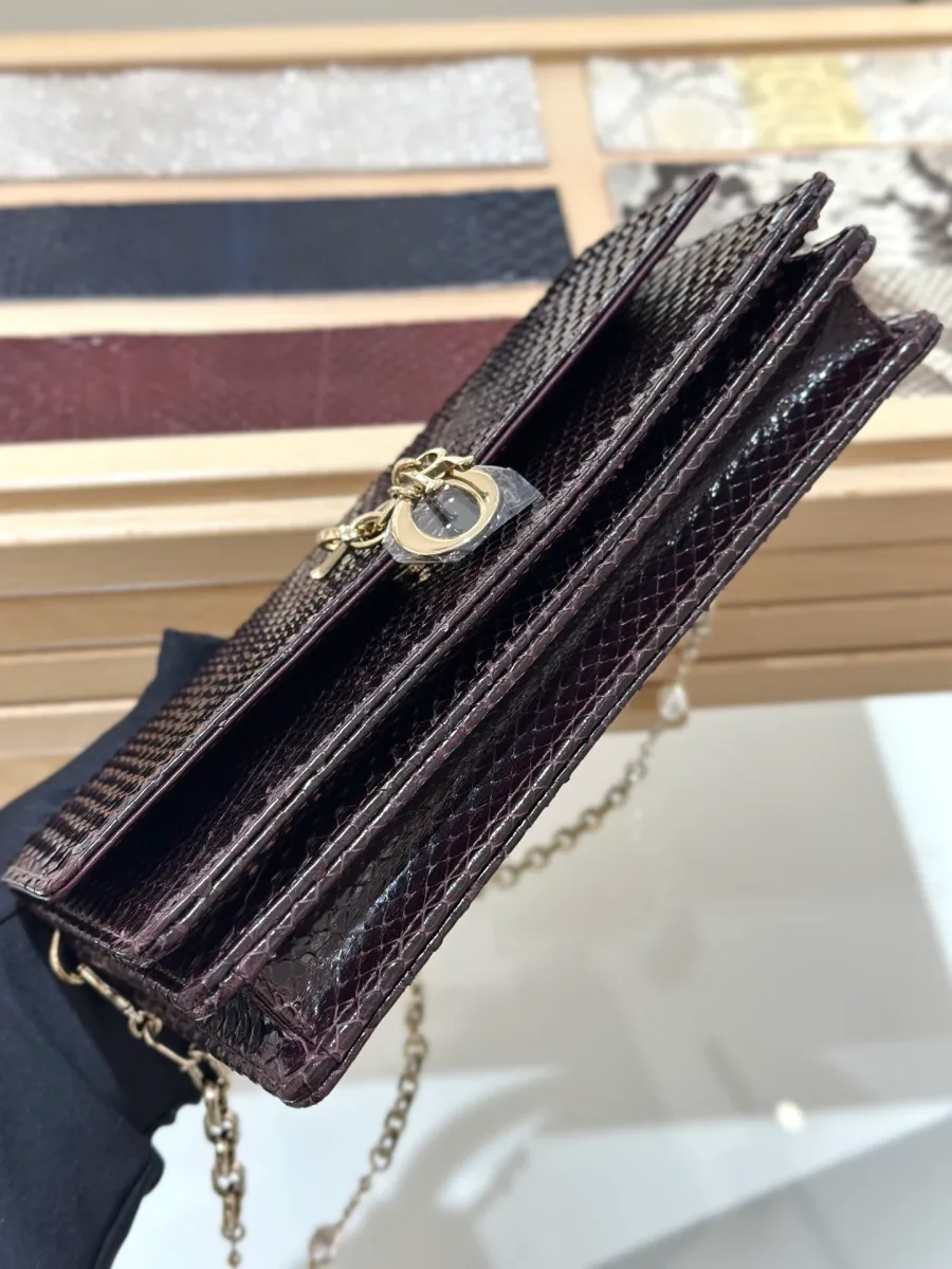 Вид снизу на бордовый клатч Dior WOC из кожи змеи