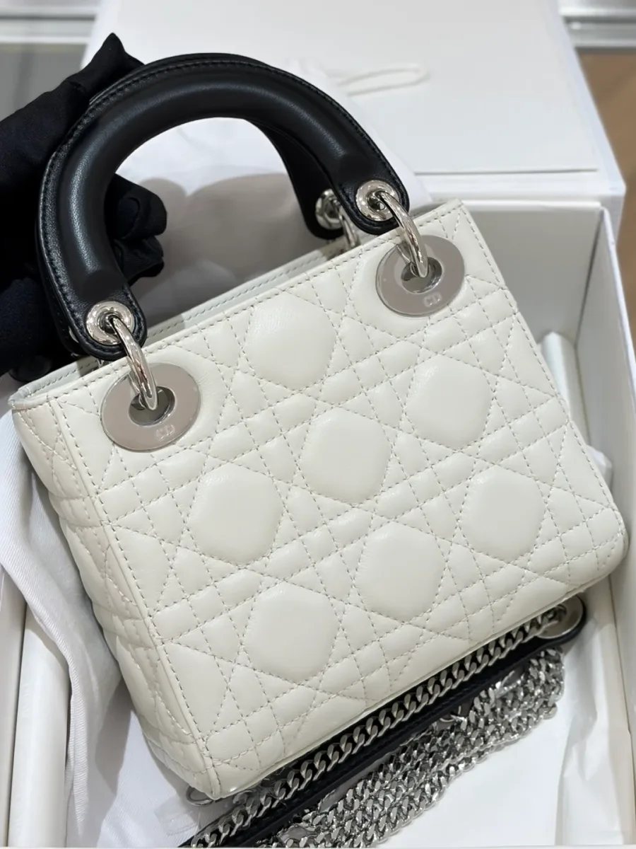Белая стеганая сумка Lady Dior с черными ручками, вид спереди под углом