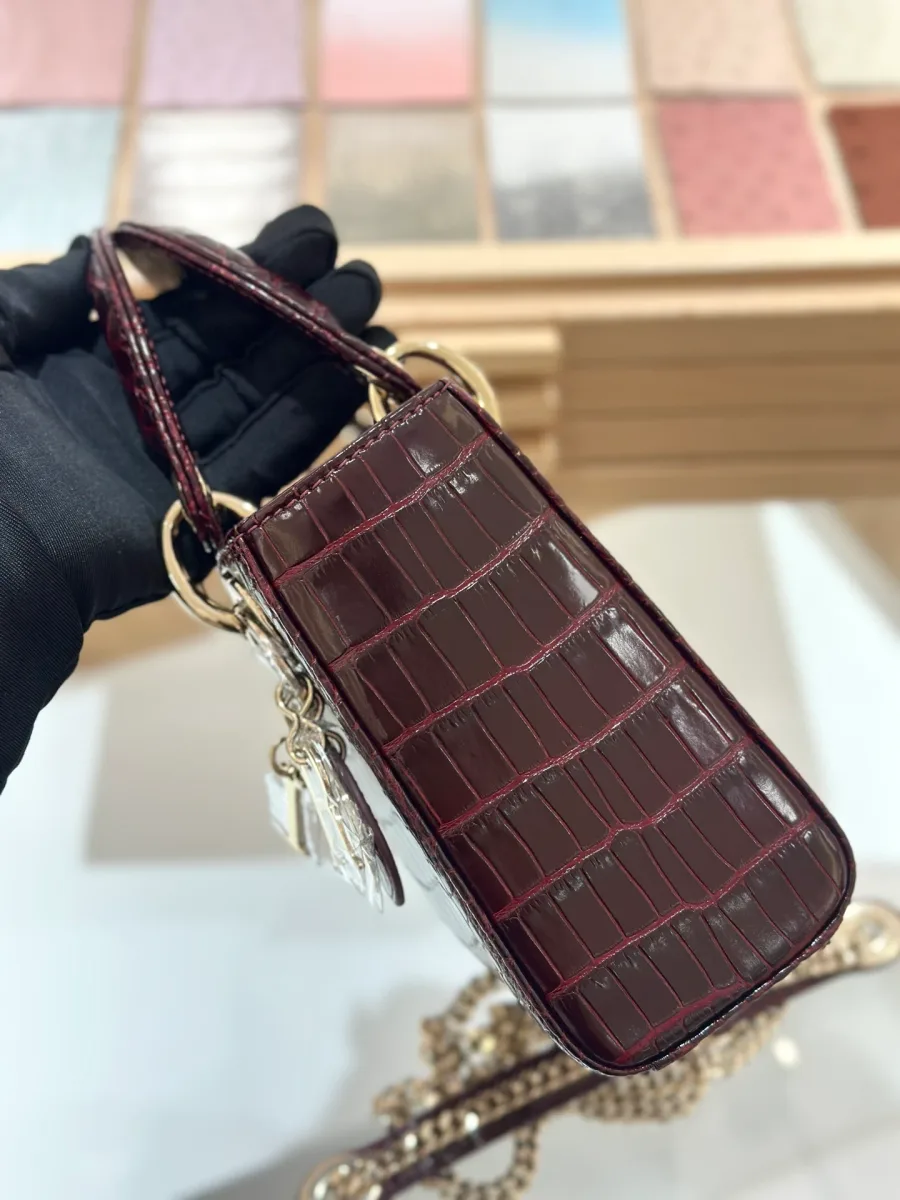 Вид сбоку на бордовую сумку Lady Dior 17 с золотистой цепочкой