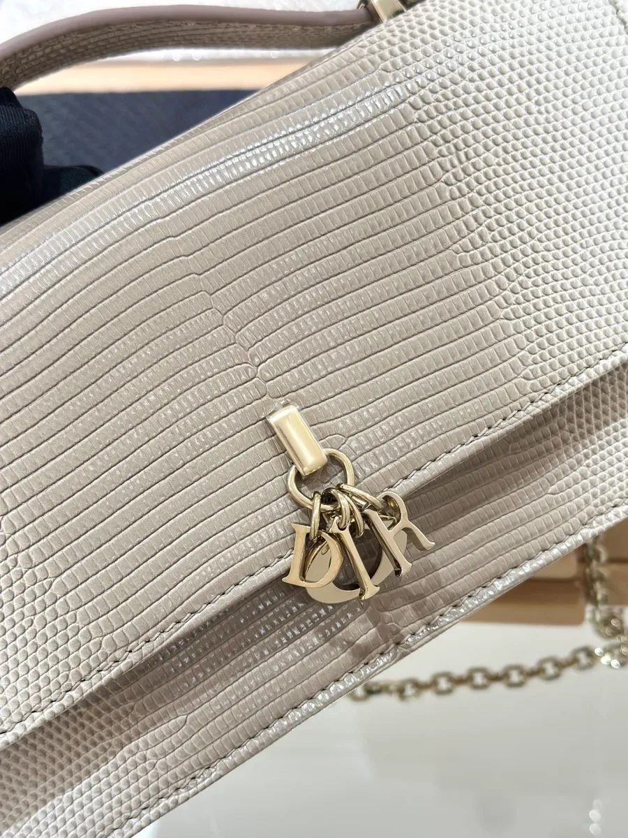 Деталь клапана сумки из кожи ящерицы с золотистой подвеской DIOR