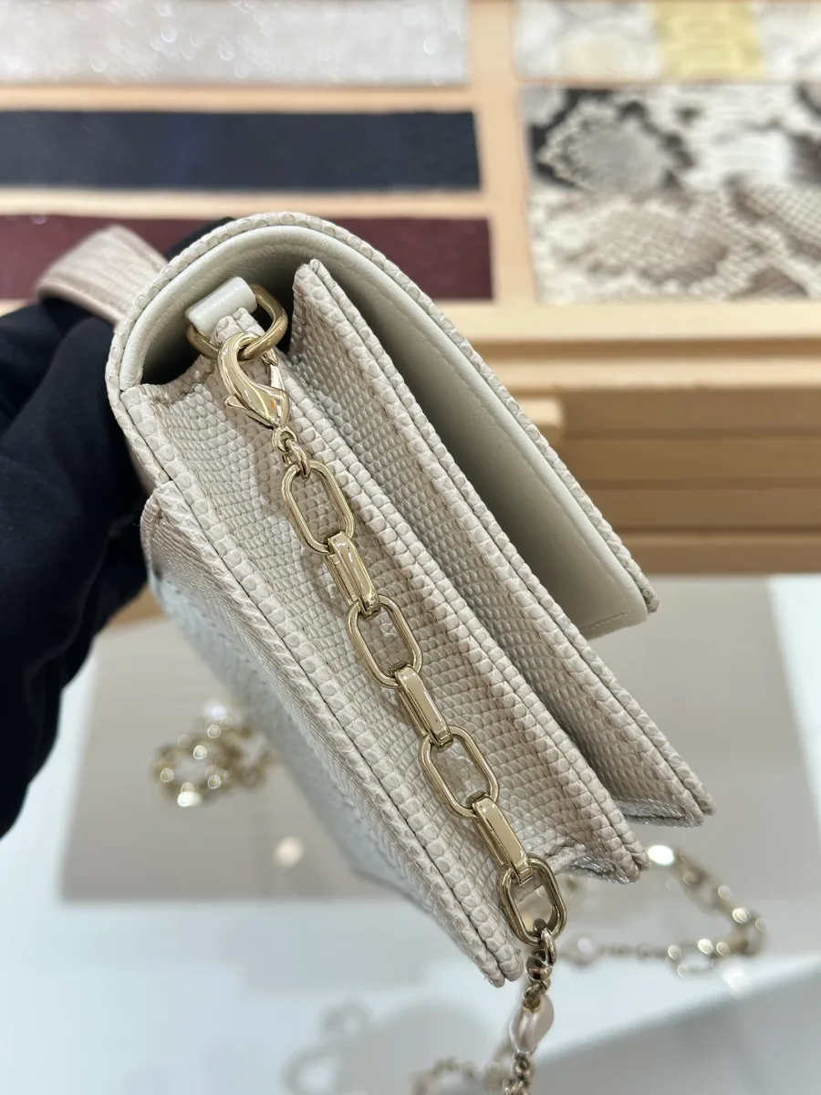 Боковая сторона сумки Dior WOC, демонстрирующая крепление цепочки